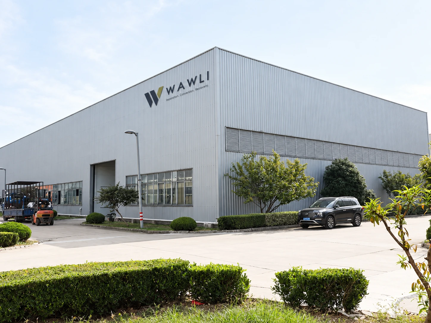 Factory exterior with WAWLI signage and landscaped grounds